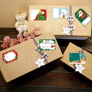 Christmas gift labels with Santa and tree motifs on kraft boxes for holiday packaging