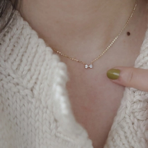 Elegant 14K gold plated S925 silver necklace featuring a sparkling bow pendant on neck