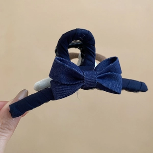 Détail d'une grande pince à cheveux en denim bleu foncé avec un nœud décoratif élégant