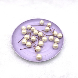 Detail of white pearl decorative picks on a purple tray for Christmas floral arrangements