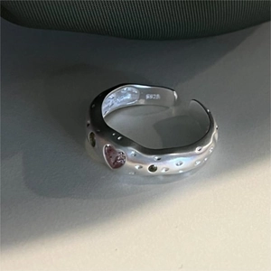 Detail of irregular 925 silver ring featuring pink heart zircon and colorful gemstones