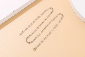 Detailed view of silver O-chain necklace with lobster clasp on minimalist background