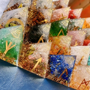 Detailed pile of Orgone energy pyramids with mixed natural stones and gold foil details