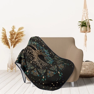 Close-up of flannel sofa blanket featuring Tree of Life pattern in a cozy home setting