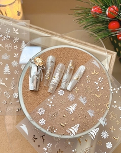 Détail de stickers à ongles de Noël avec flocons et rennes dorés en relief gaufré