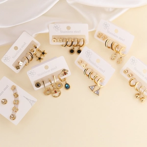 Flat lay detail of gold stainless steel stud earring set with bear and star pendants