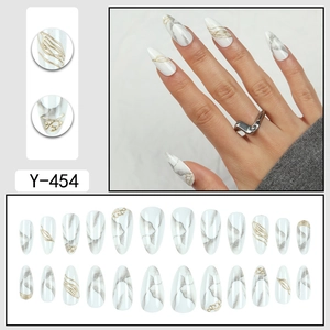 Unghie finte a pressione con trama marmo bianco e linee dorate in forma mandorla