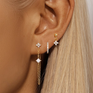 Detailed view of gold tassel earrings set with zircon flowers and long chain charms