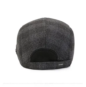 Detail view of the gray plaid flat cap featuring a knit elastic back and narason label