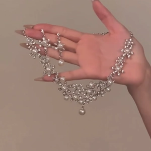 Detail of silver floral necklace and earrings set with sparkling rhinestones and pearls