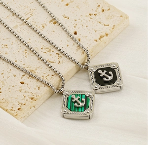 Detail of square anchor pendant with woven border on textured stone background