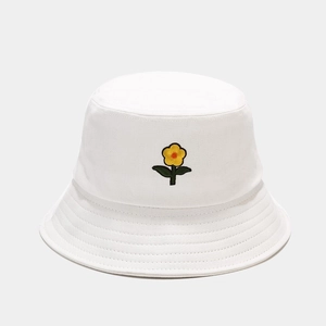 Dettaglio ravvicinato del ricamo a fiori gialli su cappello a secchiello bianco