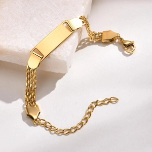 Detailed macro view of the gold-plated mesh ID bracelet with a blank engravable metal plate