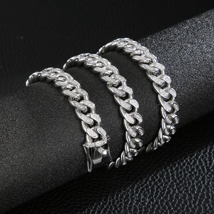 Macro shot of silver hip-hop Cuban link chain with sparkling pavé-set zircons on black display