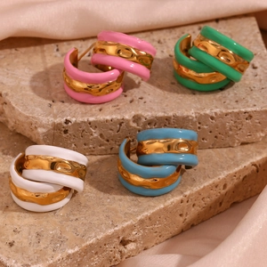 Detail of vintage enamel hoop earrings in pink green white and blue with gold texture