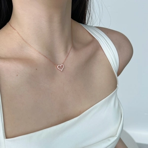 Detail of rose gold S925 silver heart necklace with pavé zircons on a model's neck