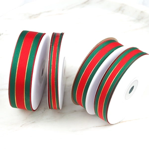 Detailed view of red and green striped grosgrain ribbons in various widths on marble