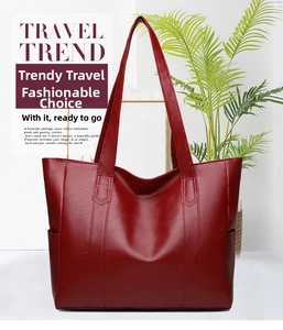 Close-up of red lychee textured leather tote bag showing side pockets and stitching
