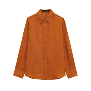 Dettaglio del colletto di camicia in lino arancione con trama tessuto ed etichetta