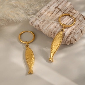 Detailed close-up of gold fish pendant hoop earrings featuring intricate scale textures