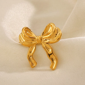 Polished 18K gold plated stainless steel bow ring on elegant beige satin backdrop