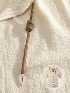 Détail de la texture en lin de coton beige avec cordons tressés et boutons en bois