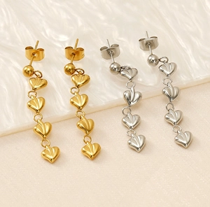 Vue détaillée de longues boucles d'oreilles cœur pendantes en finitions or et argent