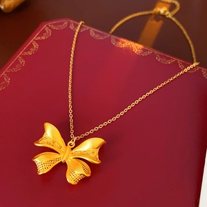 Detailed close-up of 18K gold butterfly stud earrings with hollow design and textured finish