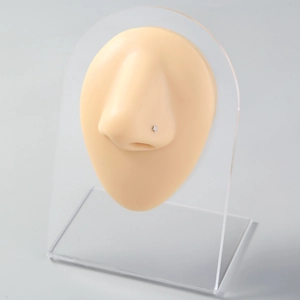 Detailed view of silver star nose stud jewelry on a mannequin for facial piercing