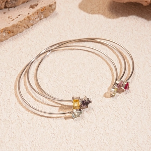 Vue détaillée de trois bracelets argentés ajustables avec des pierres de zircon colorées