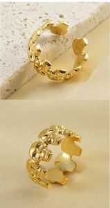 Close-up of golden adjustable punk skull ring on white rock and silk backgrounds