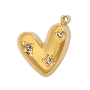 Macro shot of gold heart pendant with three sparkling crystals on a white backdrop