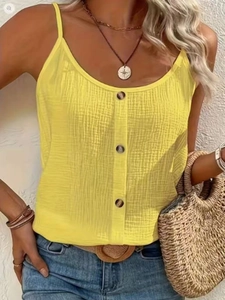 Detail of yellow cotton-linen tank top showing decorative buttons and textured fabric
