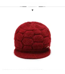 Detailed macro view of dark red knit hat featuring honeycomb texture and golden bow