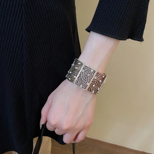 Close-up of vintage hollow cuff bracelet with spiral patterns and small white crystals