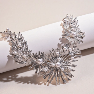 Macro shot of silver metallic coral-shaped necklace featuring inlaid white pearls