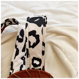 Detail of cow print canvas strap and brown suede fabric on fashion western backpack