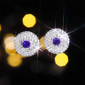 Luxurious silver round earrings featuring a blue faceted gemstone with white crystal halo