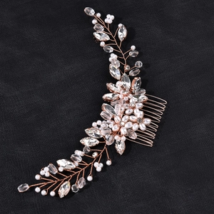 Detail of rose gold hair comb with white pearls and leaf-shaped crystals on black leather