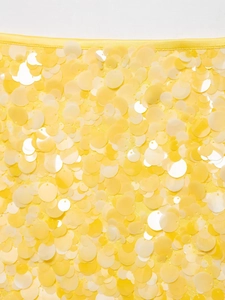 Vue macro d'un tissu à paillettes jaunes avec des motifs circulaires et brillants