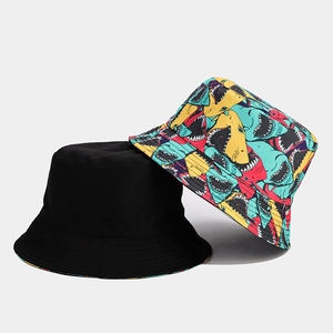 Dettaglio del cappello reversibile con lato nero e stampa vivace con squali colorati
