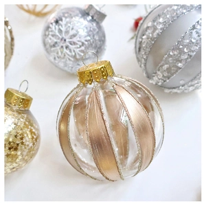 Close-up of glass Christmas ball with rose gold glitter stripes and gold metal cap