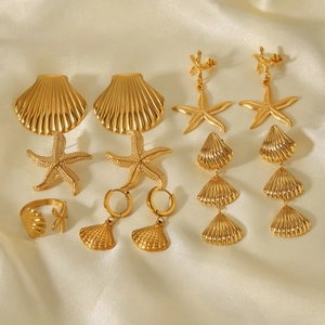 Detailed set of 18k gold starfish and shell earrings with a ring on silk background