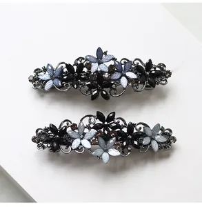 Macro detail of retro hollow-carved alloy flower hair clips with vintage rhinestones