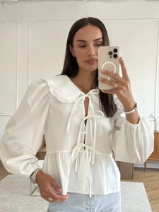 Chic white long sleeve cotton blouse with tie-neck and puff sleeves for casual style