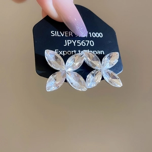Detail of silver clover earrings with clear crystals and 925 silver certification tag