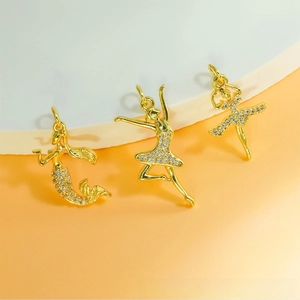 Detailed view of gold mermaid and ballet dancer pendants with shimmering zircon accents