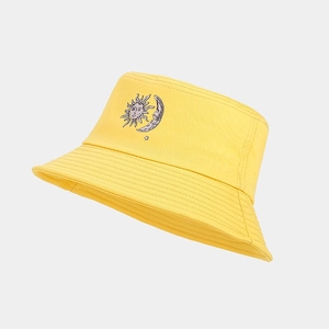 Detailed close-up of yellow bucket hat with sun and moon embroidery and stitching