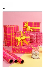 Détail de rouleaux de papier cadeau rose Happy Birthday avec des nœuds en satin jaune