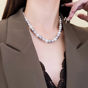 Detail of elegant pearl necklace with white and grey gradient on a professional model